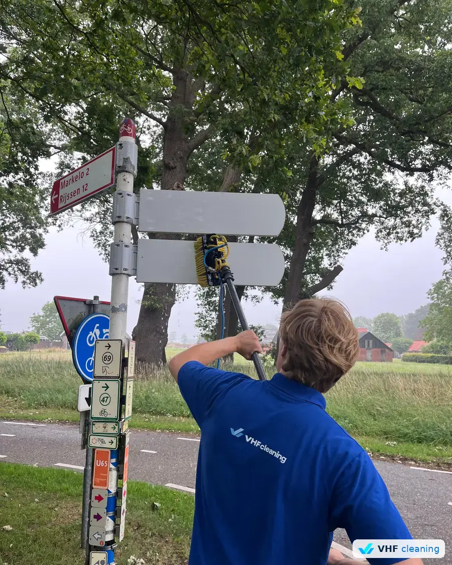 Wout Veehof reinigt bewegwijzering bij Markelo in opdracht van gemeente Hof van Twente